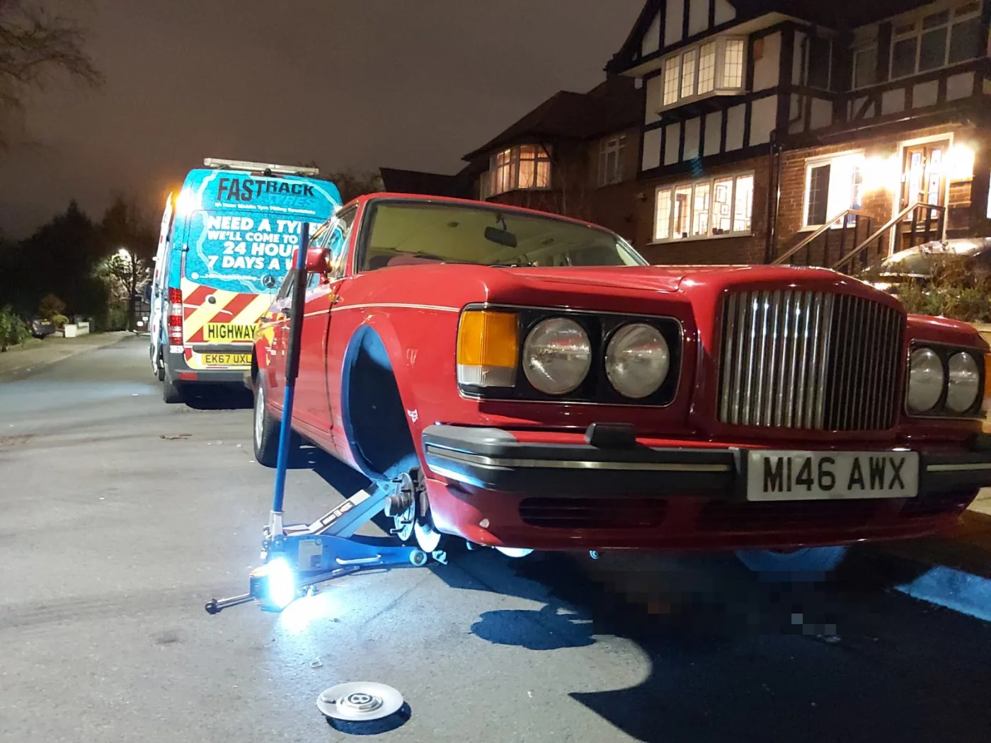 Classic red Bentley Turbo R on a night-time mobile tyre change outside a London home