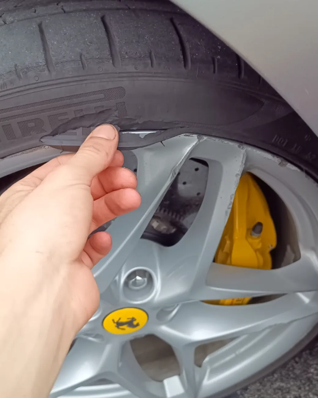 Close-up of a damaged Pirelli tyre sidewall on a Ferrari wheel