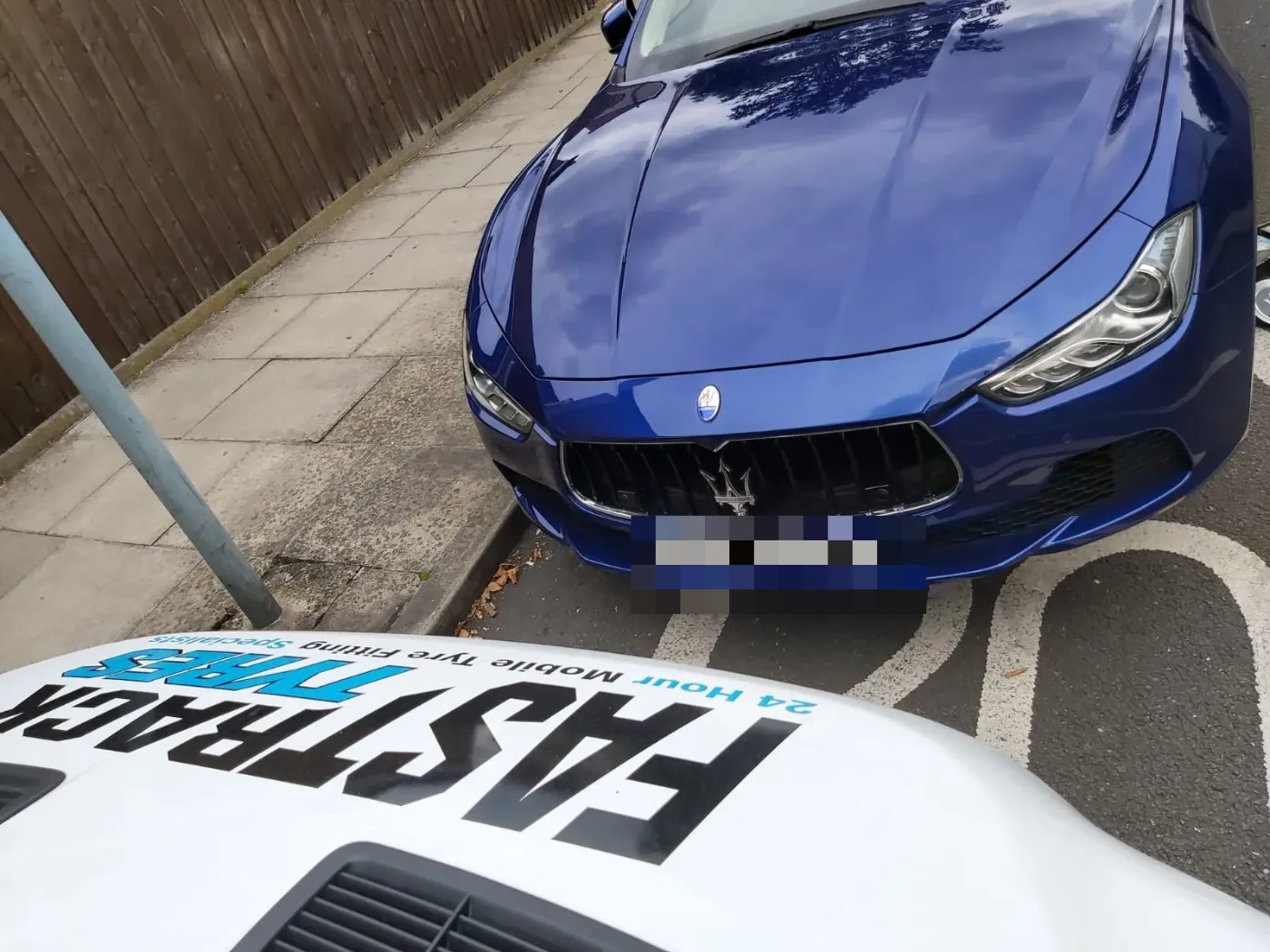 Blue Maserati Ghibli front view with the Fastrack Tyres van in the foreground during a tyre call-out