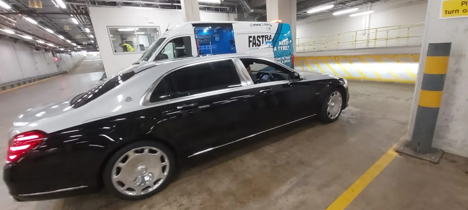 Two-tone black and silver Mercedes-Maybach S-Class in an underground car park during a wheel change
