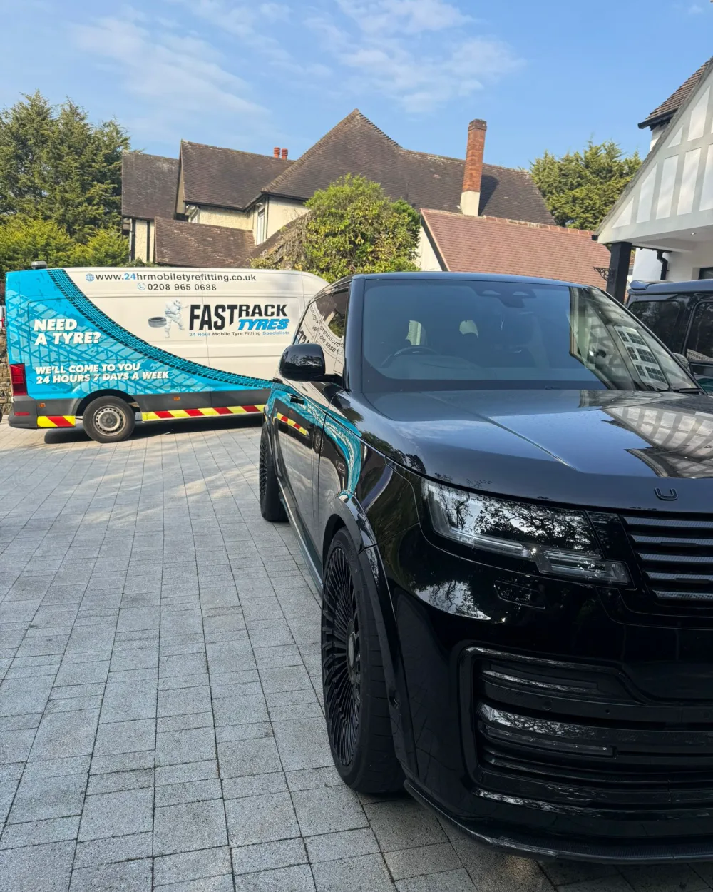 Black Range Rover having tyres fitted at home with the Fastrack mobile van on the driveway