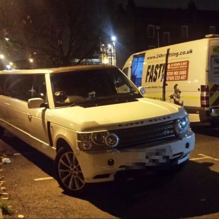 White stretch-limousine Range Rover being attended at night with the Fastrack Tyres van behind